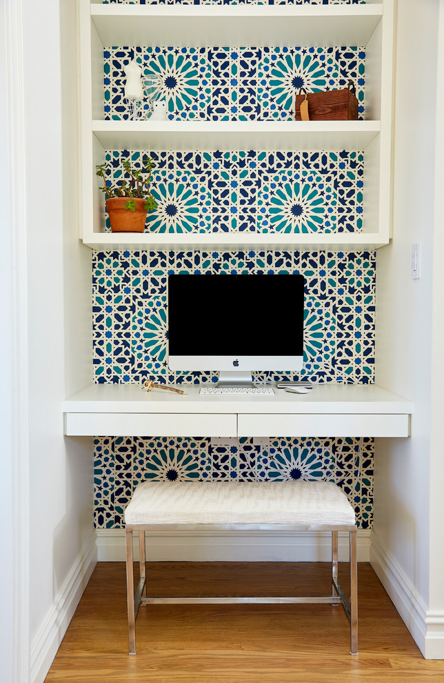 Exempel på ett litet modernt könsneutralt barnrum kombinerat med skrivbord, med mellanmörkt trägolv och flerfärgade väggar