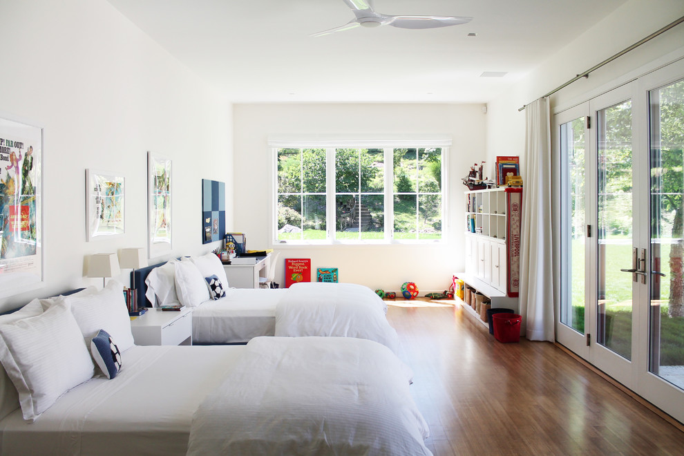Large children’s room for boys in New York with white walls and bamboo flooring.