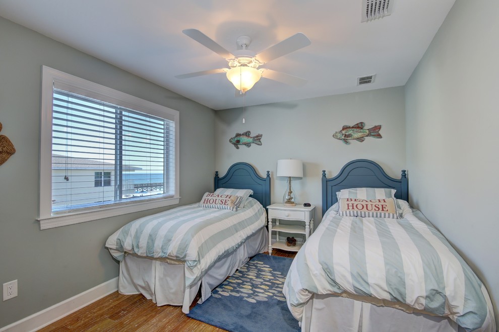 Foto på ett mellanstort maritimt pojkrum kombinerat med sovrum och för 4-10-åringar, med blå väggar och bambugolv