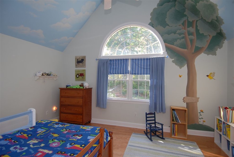Esempio di una cameretta per bambini da 4 a 10 anni minimalista di medie dimensioni con pareti multicolore e parquet chiaro