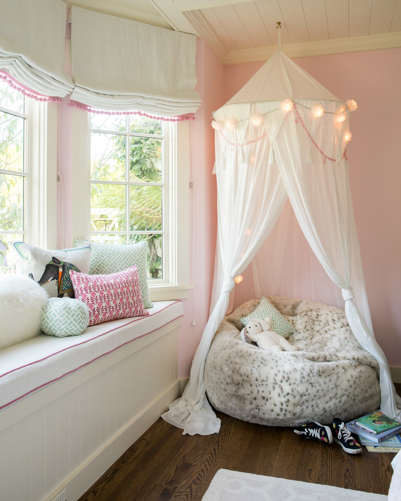 Foto på ett vintage barnrum kombinerat med sovrum, med rosa väggar, mörkt trägolv och brunt golv