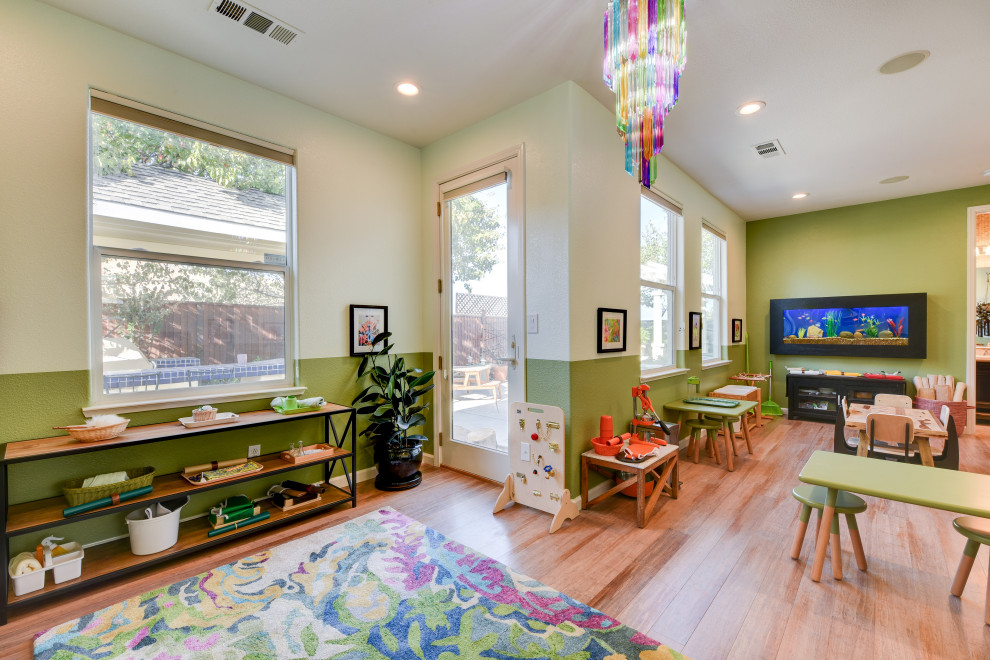 Foto de habitación infantil unisex de 1 a 3 años contemporánea de tamaño medio con escritorio, paredes verdes, suelo de madera en tonos medios y suelo marrón
