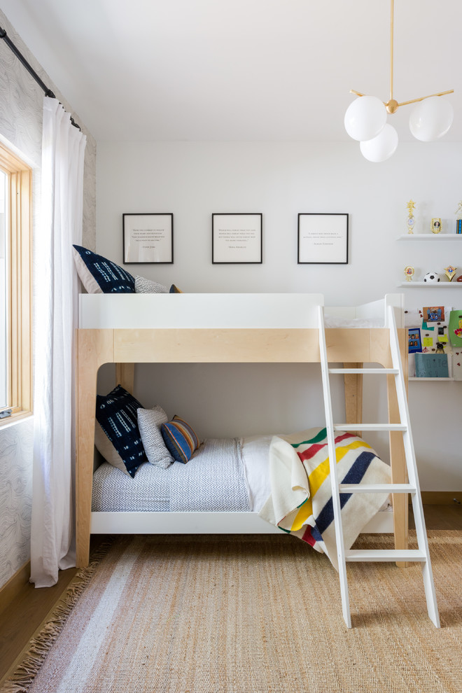 Immagine di una cameretta per bambini da 4 a 10 anni minimal di medie dimensioni con pareti bianche, parquet chiaro e pavimento marrone
