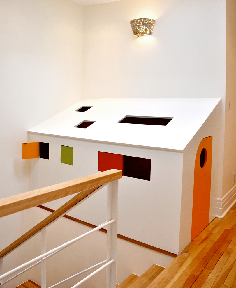 Minimalist gender-neutral medium tone wood floor playroom photo in Montreal with white walls