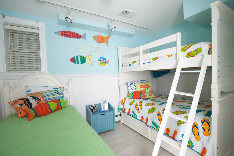 Ejemplo de dormitorio infantil de 4 a 10 años costero pequeño con paredes azules y suelo de madera clara
