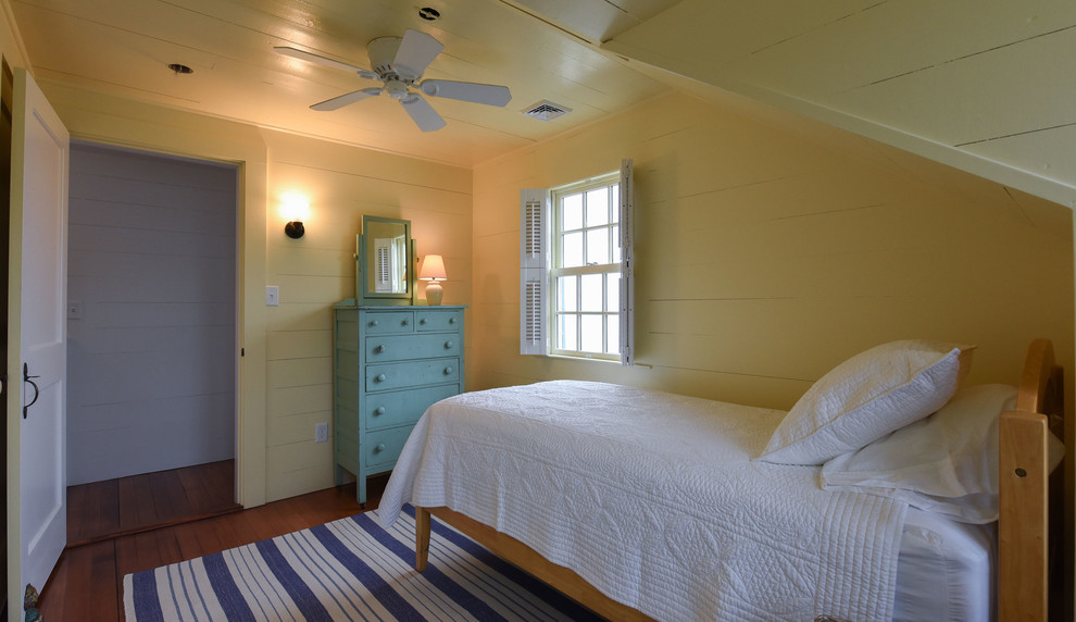 Maritimes Kinderzimmer mit Schlafplatz, gelber Wandfarbe, braunem Holzboden und braunem Boden in Boston