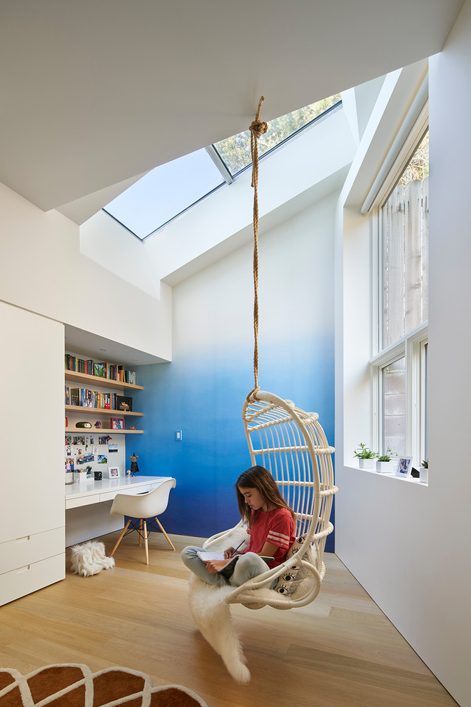 Aménagement d'une chambre d'enfant contemporaine avec un mur bleu, parquet clair et un sol marron.