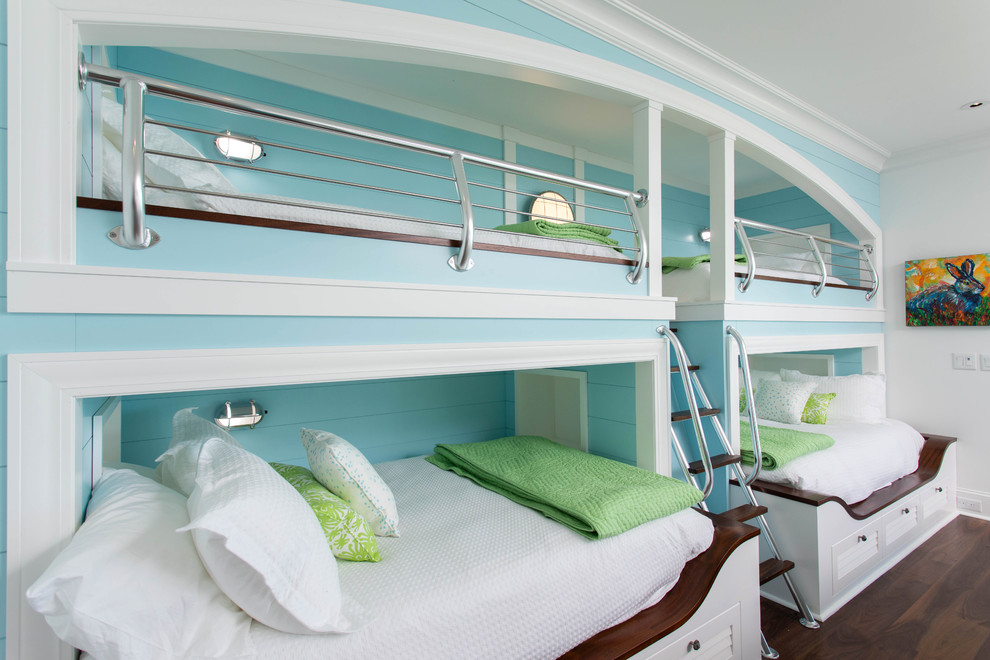 Exempel på ett maritimt könsneutralt barnrum kombinerat med sovrum och för 4-10-åringar, med blå väggar, mörkt trägolv och brunt golv