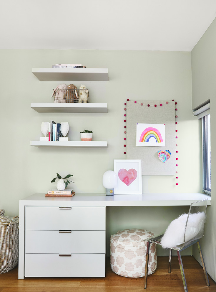 Idée de décoration pour une grande chambre de fille de 4 à 10 ans design avec un bureau, un mur gris, un sol en bois brun et un sol marron.