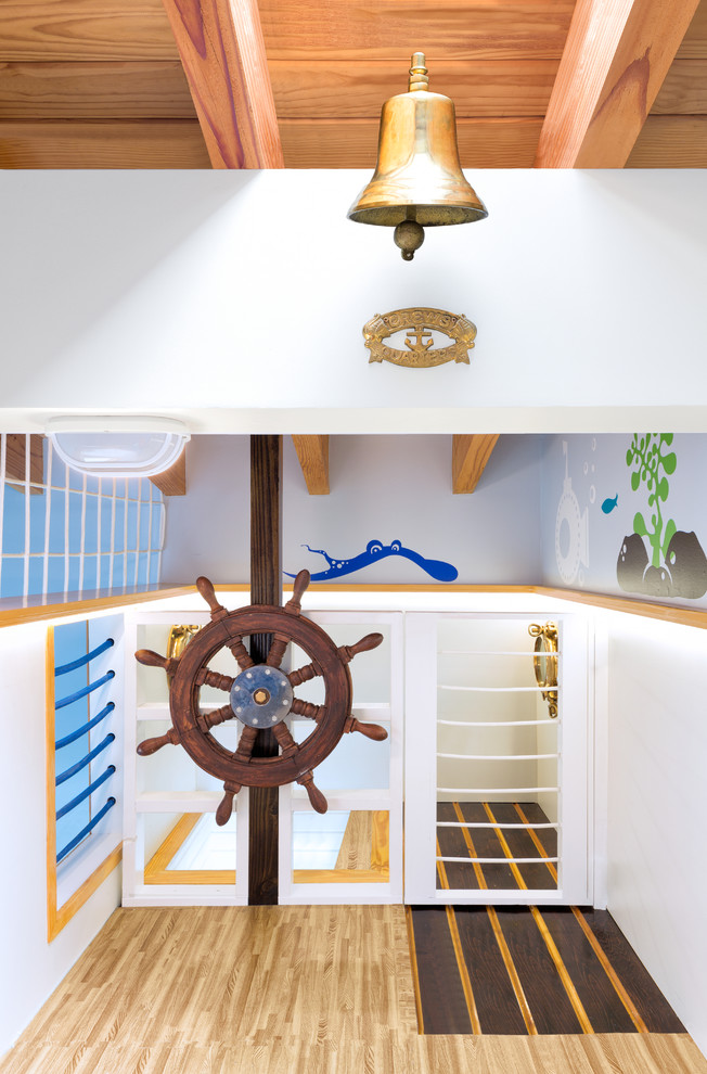 Idee per una grande cameretta per bambini da 4 a 10 anni stile marino con pareti blu e parquet chiaro