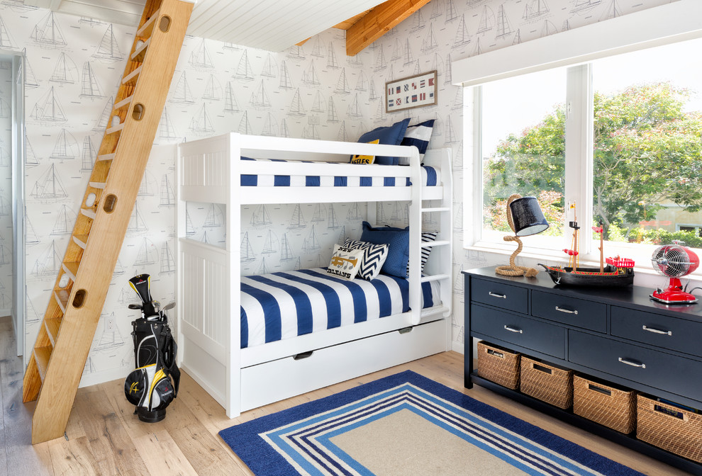 Maritim inredning av ett mellanstort pojkrum kombinerat med sovrum och för 4-10-åringar, med ljust trägolv och flerfärgade väggar