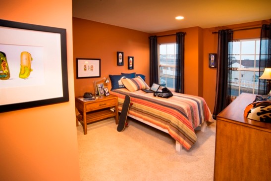 Réalisation d'une chambre d'enfant tradition avec moquette et un mur orange.