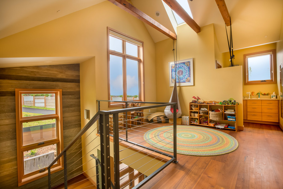 Mittelgroßes, Neutrales Modernes Kinderzimmer mit Spielecke, braunem Holzboden, gelber Wandfarbe und braunem Boden in Sonstige