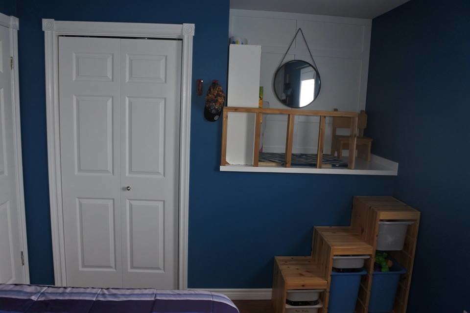 Cette photo montre une chambre d'enfant de 4 à 10 ans avec un mur bleu, sol en stratifié et un sol marron.
