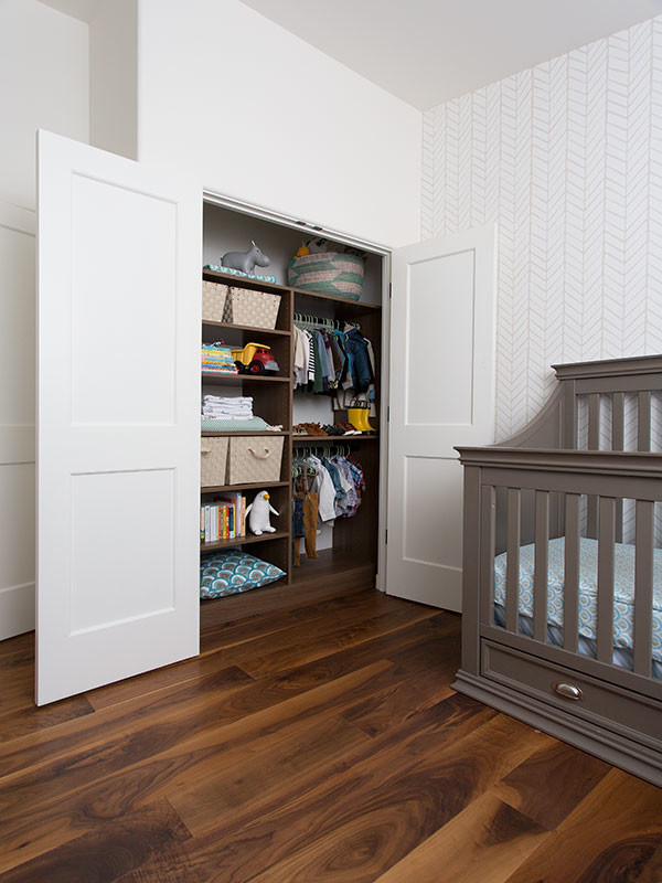 Immagine di una cameretta per bambini da 1 a 3 anni minimal con pareti bianche e pavimento in legno massello medio