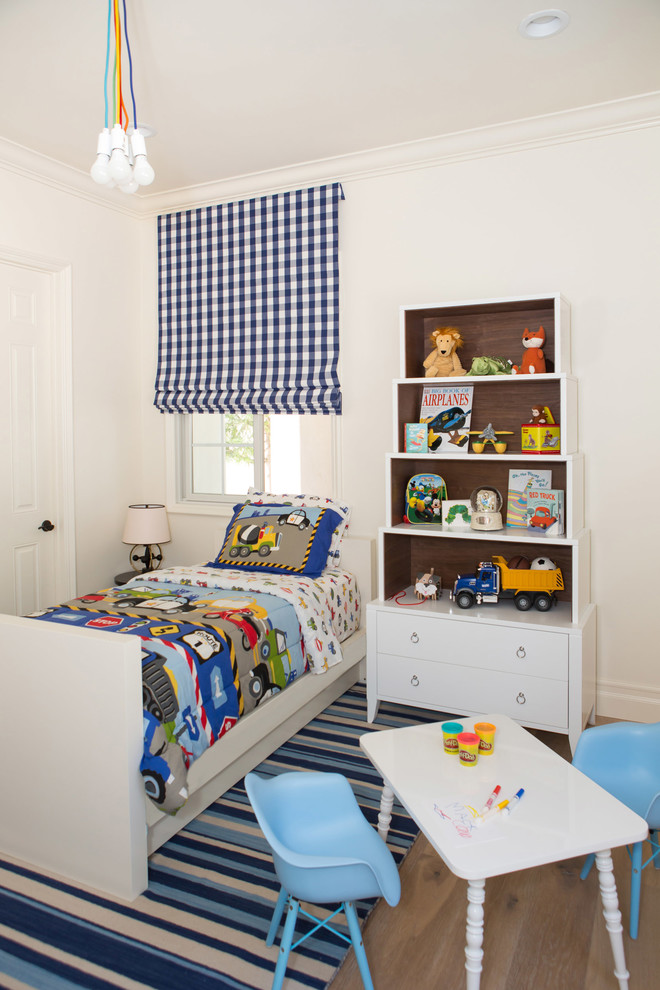 Large classic toddler’s room for boys in San Diego with white walls and medium hardwood flooring.