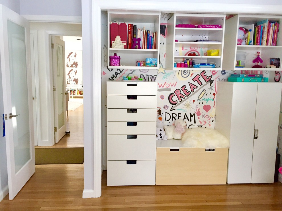 Esempio di una piccola cameretta per bambini da 4 a 10 anni minimalista con pareti viola e parquet chiaro