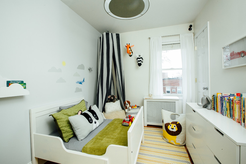 Modelo de dormitorio infantil de 1 a 3 años contemporáneo pequeño con paredes grises, suelo de madera oscura y suelo marrón