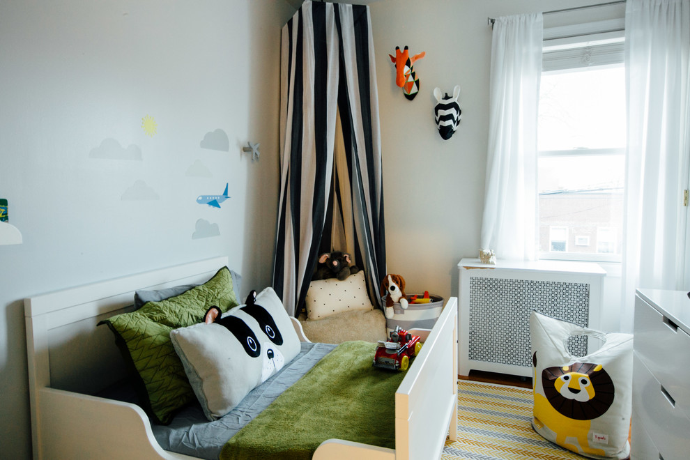 Cette image montre une petite chambre d'enfant de 1 à 3 ans design avec un mur gris, parquet foncé et un sol marron.
