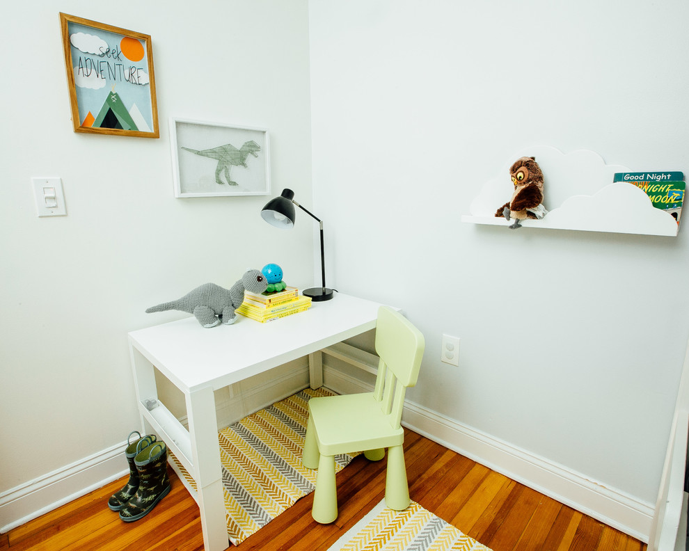 Cette photo montre une petite chambre d'enfant de 1 à 3 ans tendance avec un mur gris, parquet foncé et un sol marron.