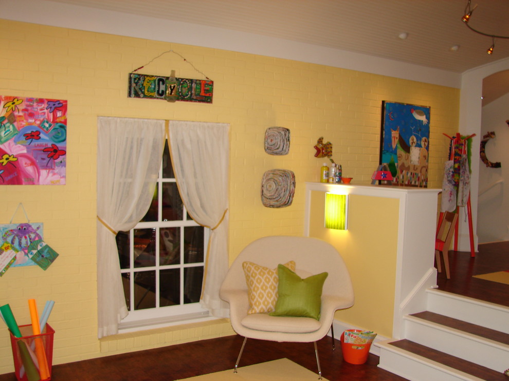 Idéer för stora vintage könsneutrala barnrum kombinerat med lekrum, med gula väggar och mellanmörkt trägolv