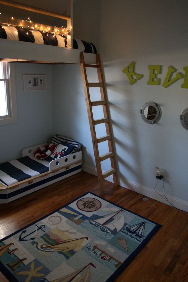 Inspiration för små maritima pojkrum kombinerat med sovrum, med blå väggar och mellanmörkt trägolv
