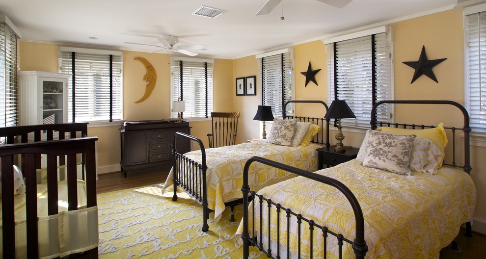 Ejemplo de dormitorio infantil de 4 a 10 años tradicional grande con paredes amarillas y suelo de madera en tonos medios