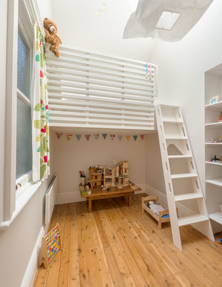 Cette image montre une chambre d'enfant de 4 à 10 ans design de taille moyenne avec un mur blanc, un sol en bois brun et un sol beige.