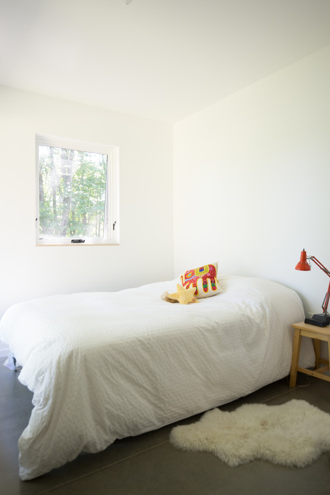 Example of a mid-sized trendy gender-neutral concrete floor and gray floor kids' room design in Burlington with white walls