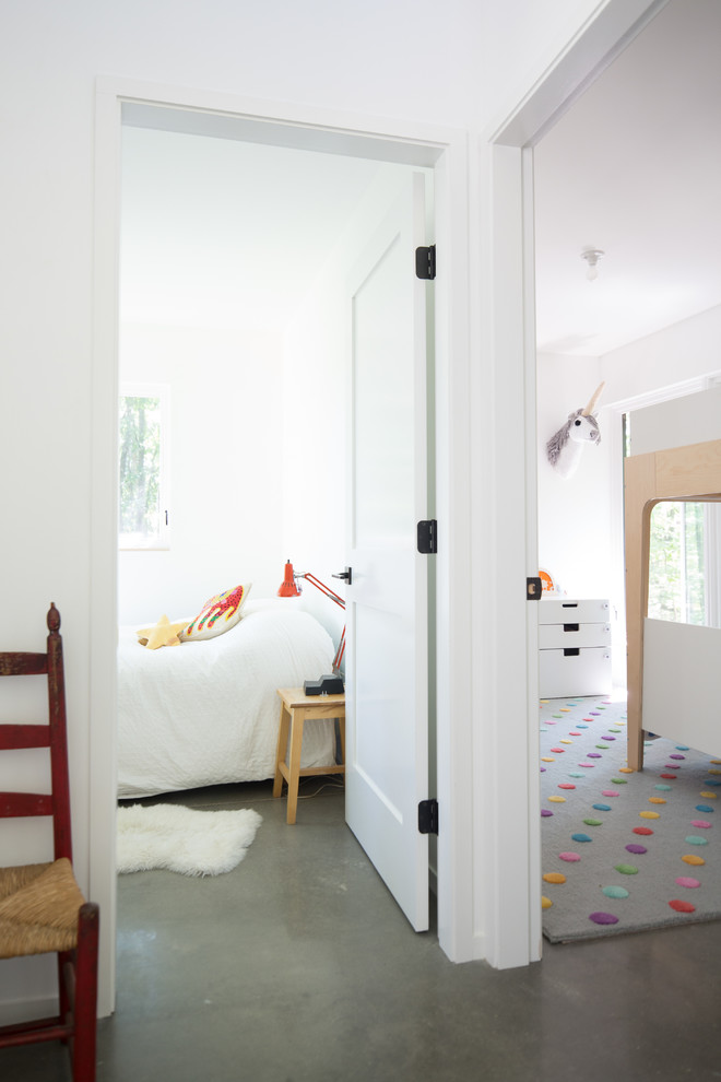 Cette image montre une chambre d'enfant de 4 à 10 ans design de taille moyenne avec un mur blanc, sol en béton ciré et un sol gris.
