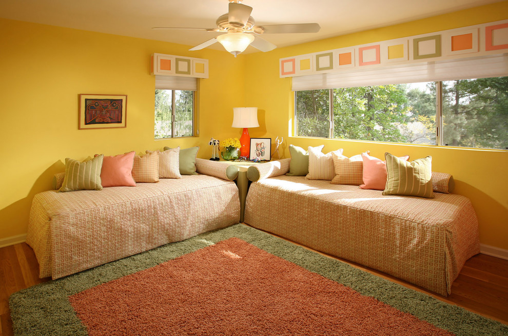Foto di una cameretta per bambini da 4 a 10 anni chic di medie dimensioni con pareti gialle e pavimento in legno massello medio