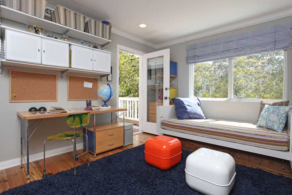 Imagen de habitación de niño de 4 a 10 años contemporánea con escritorio, paredes grises y suelo de madera en tonos medios