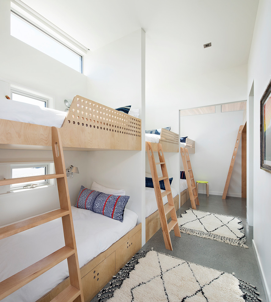 На фото: нейтральная детская в морском стиле с спальным местом, белыми стенами, бетонным полом и серым полом для двоих детей с