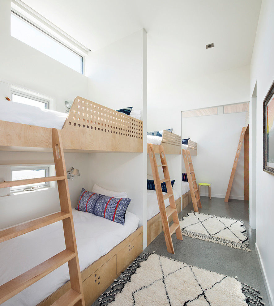 Inspiration for a nautical gender neutral kids' bedroom in San Francisco with white walls, concrete flooring and grey floors.