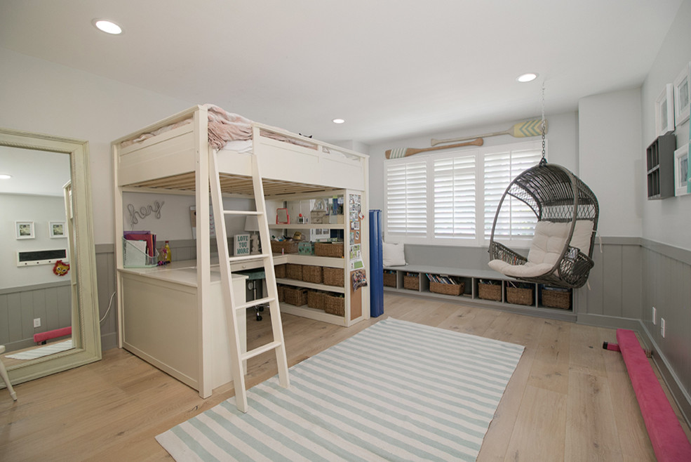 Imagen de dormitorio infantil marinero grande con paredes blancas, suelo de madera clara y suelo marrón