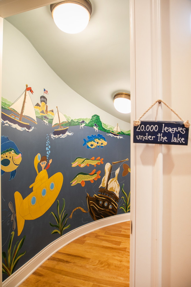 Cette photo montre une petite chambre d'enfant bord de mer avec un mur multicolore et un sol en bois brun.