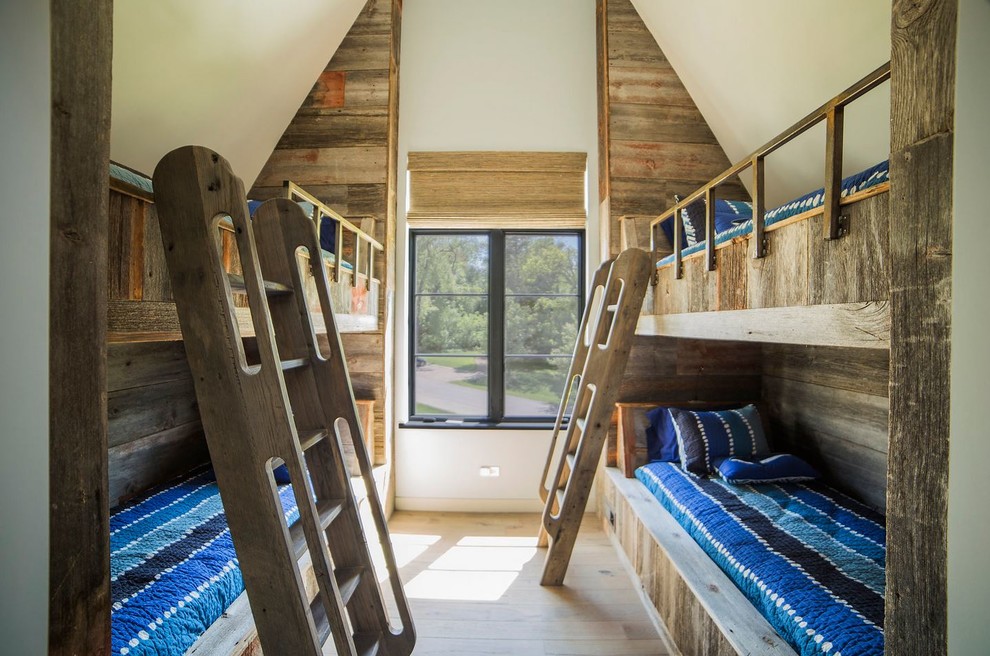Aménagement d'une grande chambre d'enfant bord de mer avec un mur bleu, parquet foncé et un lit superposé.
