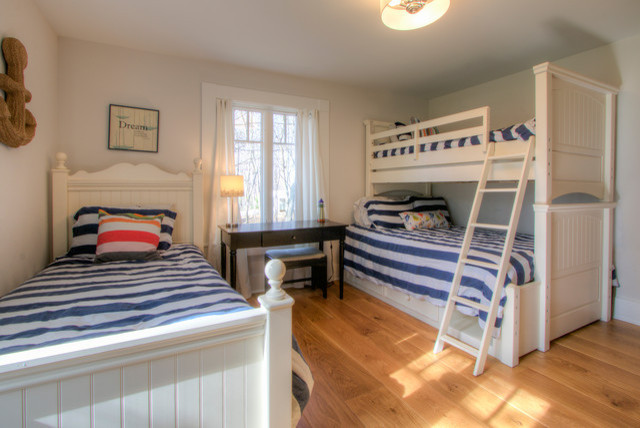Modelo de dormitorio infantil de 4 a 10 años marinero de tamaño medio con paredes beige, suelo de madera clara y suelo marrón