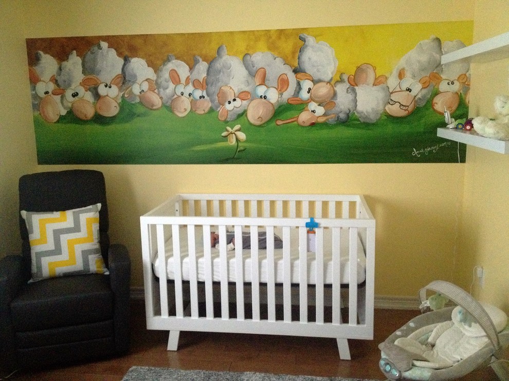 Immagine di una cameretta per neonato bohémian con pareti gialle e parquet chiaro