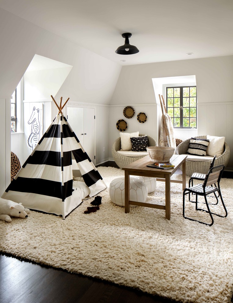 Bild på ett vintage könsneutralt barnrum kombinerat med lekrum, med vita väggar, mörkt trägolv och brunt golv