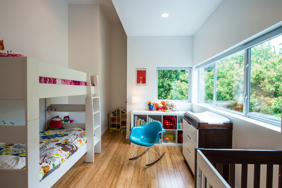 Bild på ett mellanstort funkis barnrum kombinerat med sovrum, med vita väggar och mellanmörkt trägolv