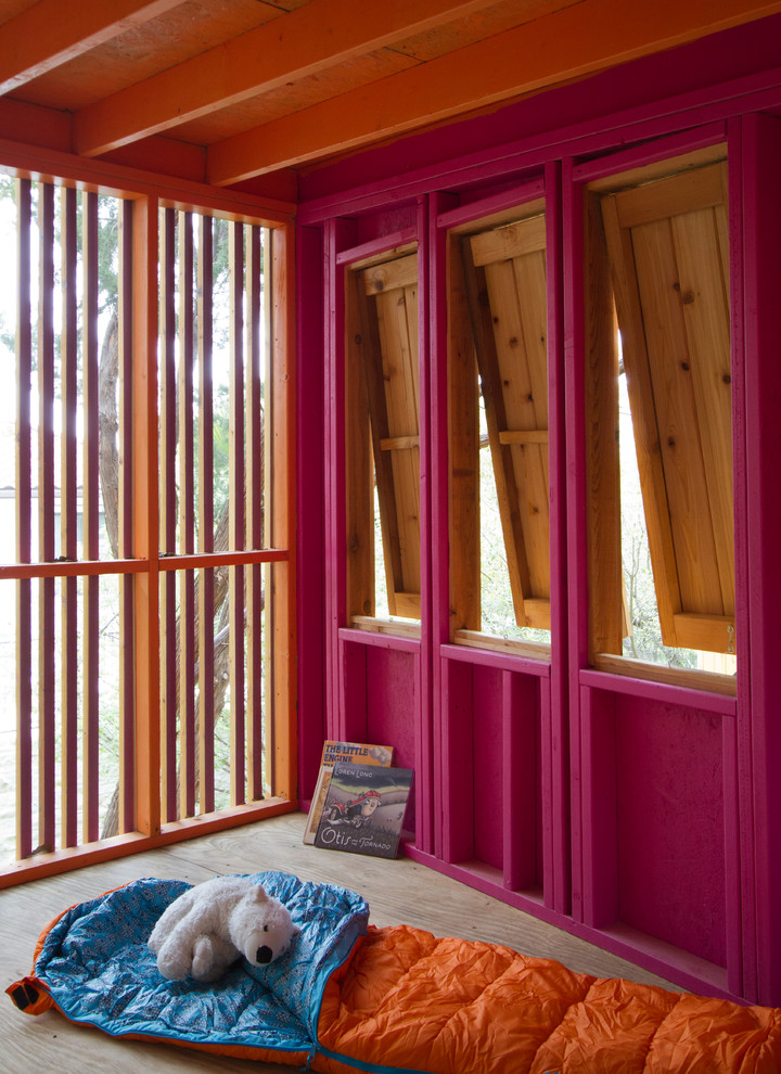 Kleines Mädchenzimmer mit Spielecke, rosa Wandfarbe, Sperrholzboden und braunem Boden in Austin
