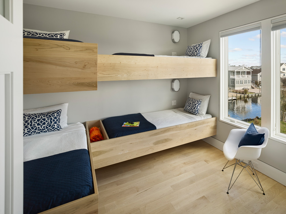 Diseño de dormitorio infantil actual pequeño con paredes grises, suelo de madera clara y suelo beige