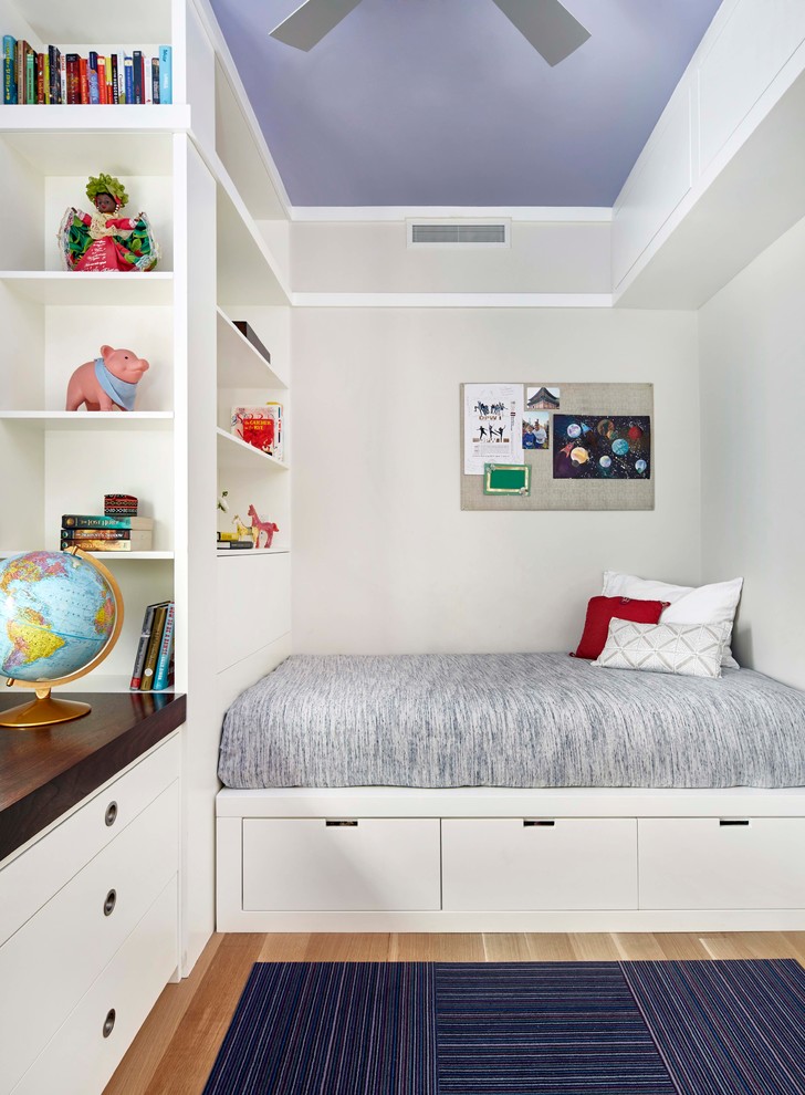 Inspiration for a contemporary children’s room for boys in New York with grey walls, light hardwood flooring and beige floors.