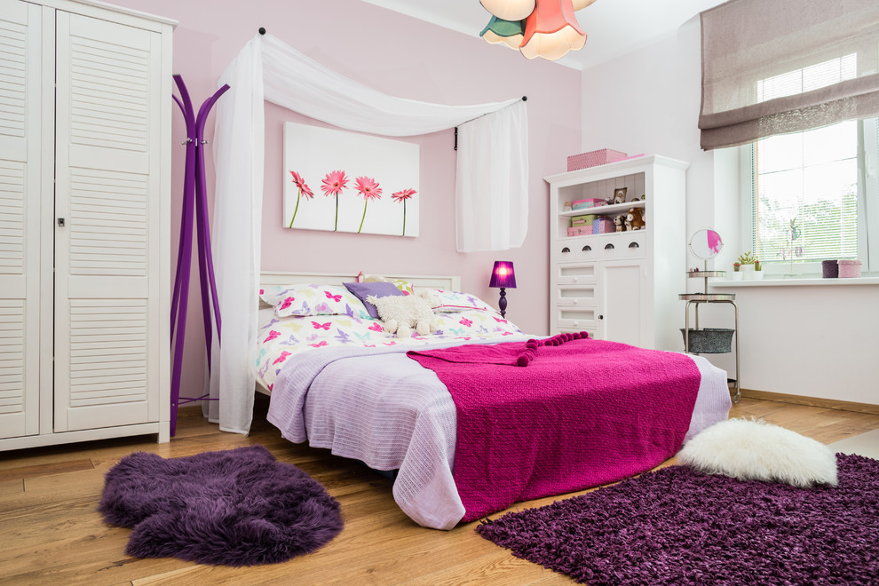 Modelo de dormitorio infantil tradicional con suelo de madera clara y paredes multicolor