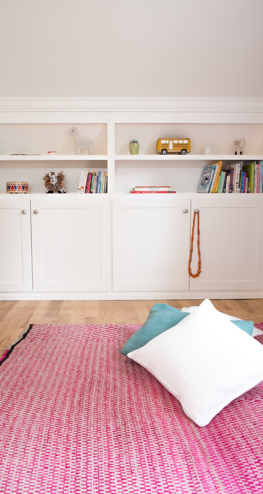 Cette image montre une petite chambre d'enfant de 4 à 10 ans bohème avec un mur blanc et un sol en bois brun.
