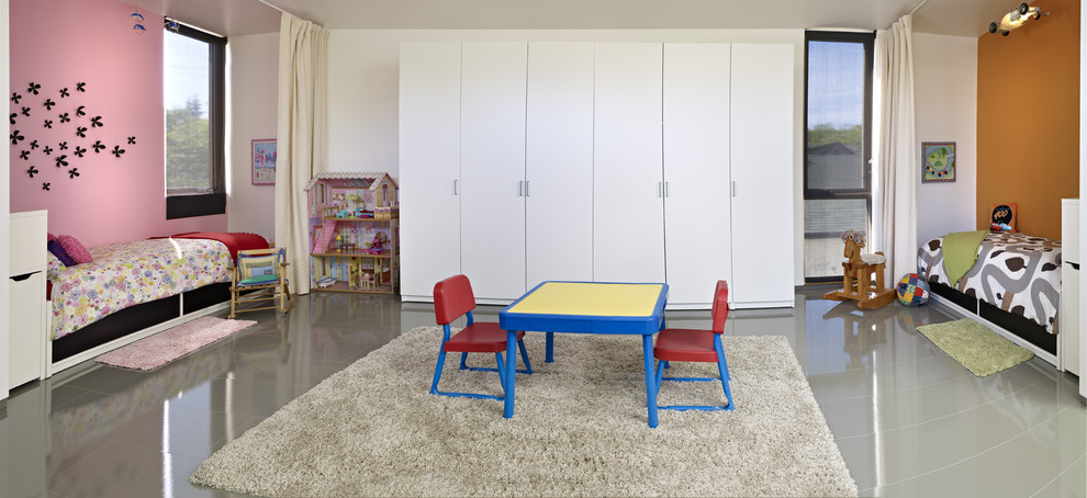 Modern inredning av ett könsneutralt småbarnsrum kombinerat med lekrum, med grått golv