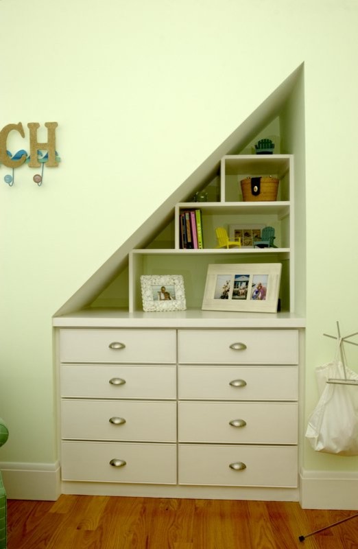 Cette image montre une chambre d'enfant minimaliste avec un mur vert et un sol en bois brun.