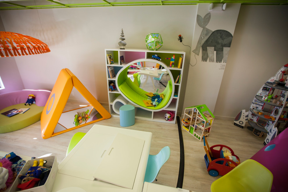 Exempel på ett stort modernt könsneutralt barnrum kombinerat med lekrum och för 4-10-åringar, med vita väggar och ljust trägolv