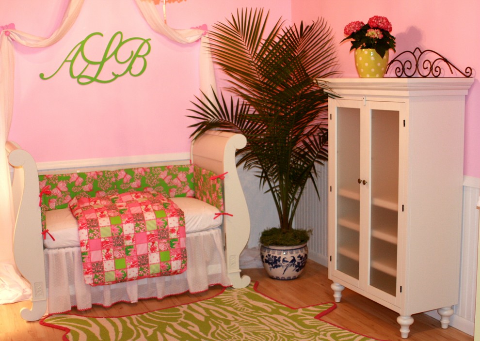 Пример оригинального дизайна: детская в стиле фьюжн с спальным местом, розовыми стенами и паркетным полом среднего тона для ребенка от 1 до 3 лет, девочки